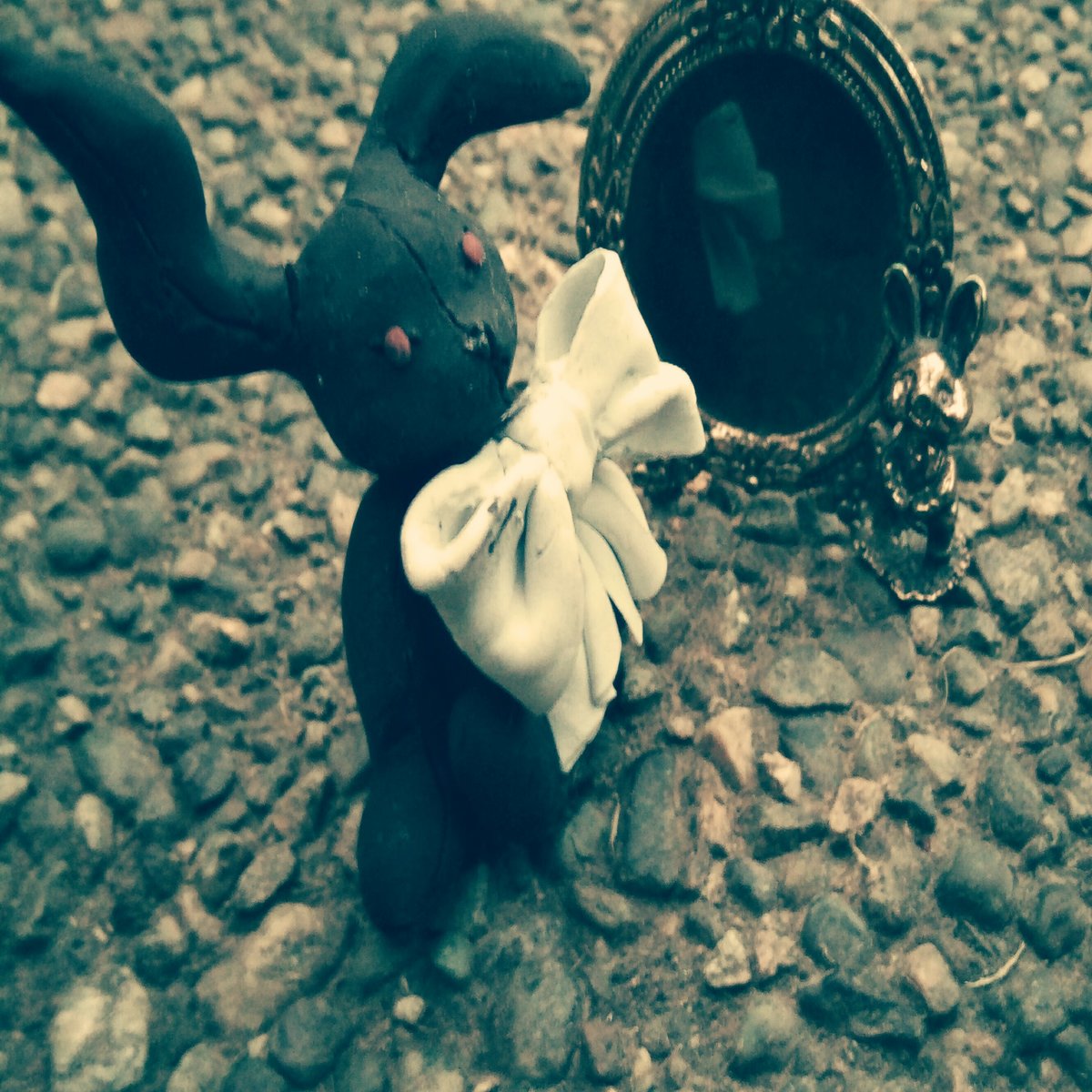A sepia photo of a black rabbit next to a mirror